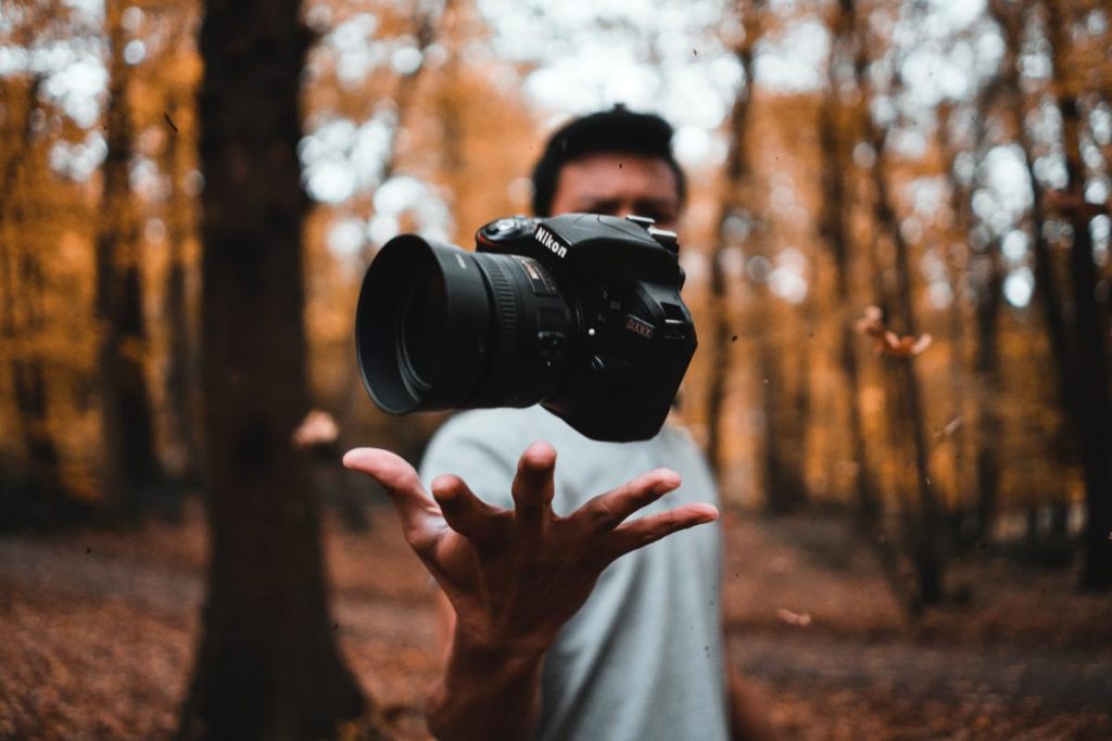 Fotograf med sit kamera i en skov